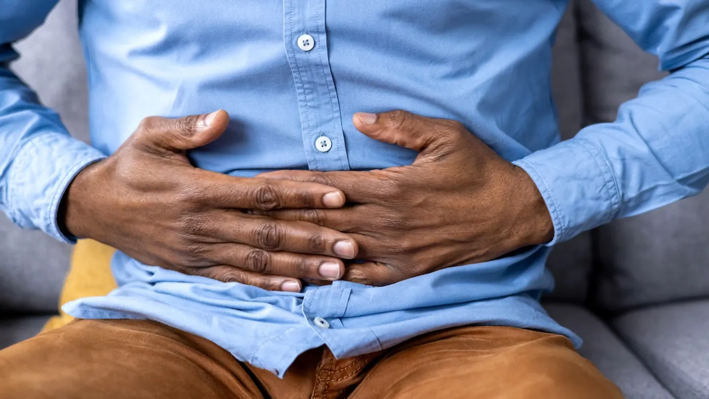Man holding stomach colon cancer sign